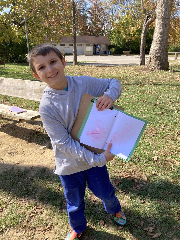 Student holding up leaf rubbing