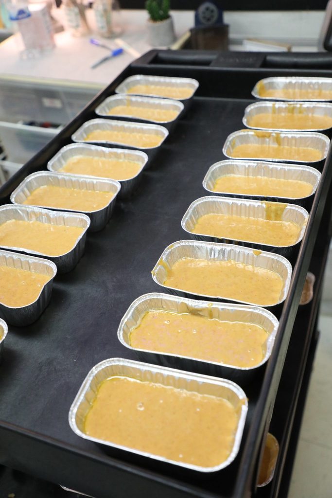 Rows of raw pumpkin bread mixture in tins