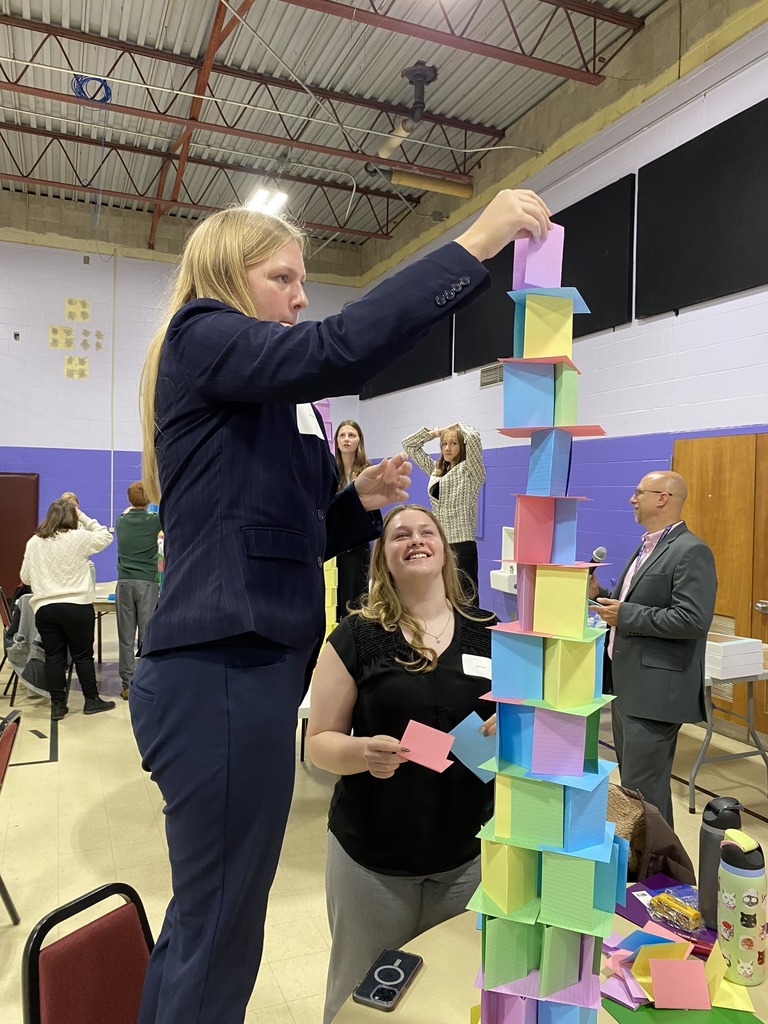 Students working together at Leadership Conference building paper tower