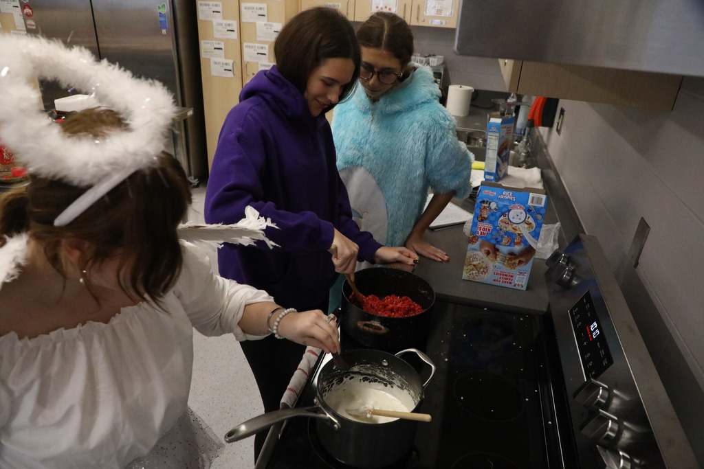 Student at stove making rice krispie treats in pot