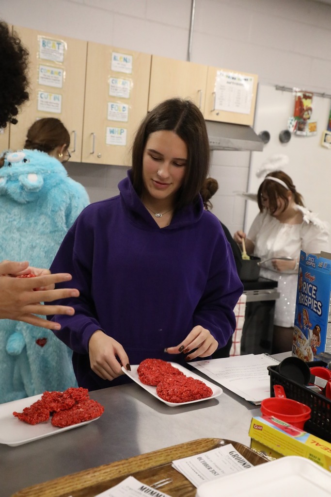 Students forming rice krispie treats on tray