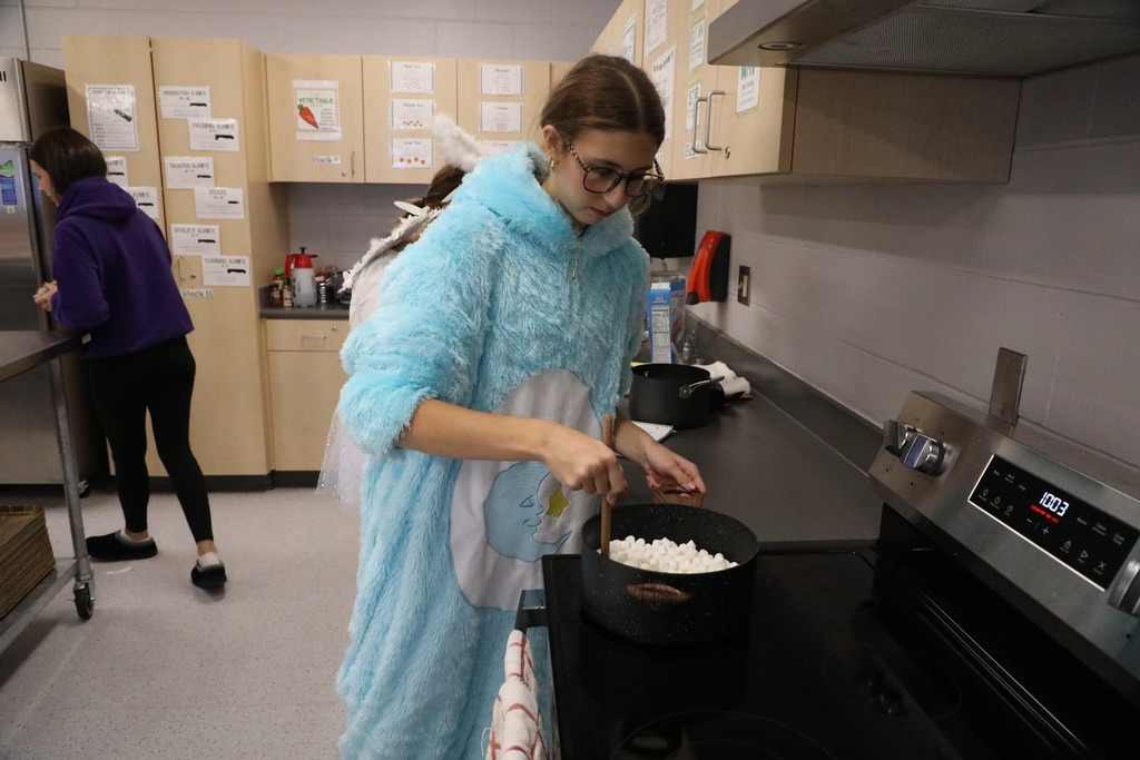 Student at stove mixing marshmallows in pot