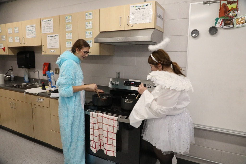 Students at stove mixing marshmallows in pot