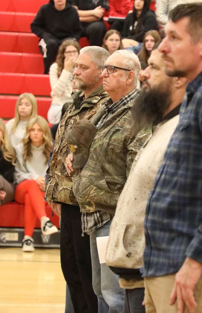 Veterans standing at Veterans Day Assembly