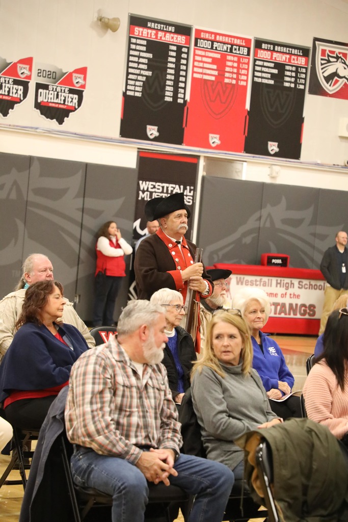 Veteran standing at Veterans Day Assembly
