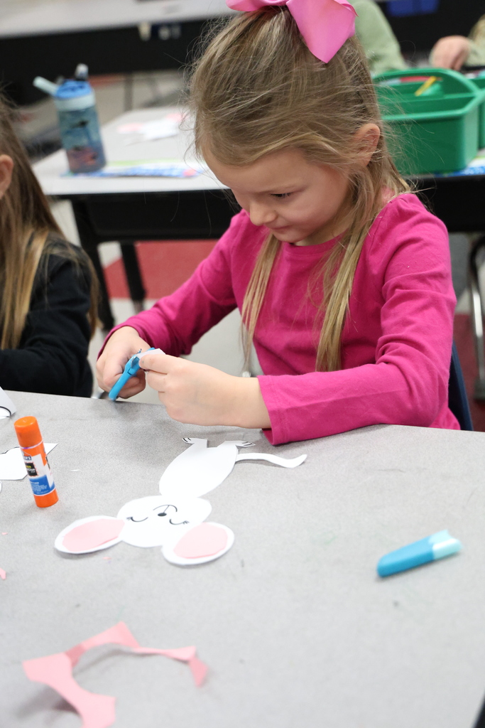 Student cutting paper with blue scissors