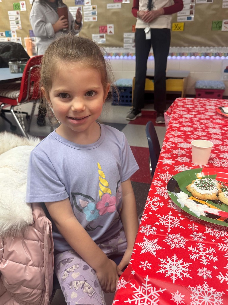 Preschoolers decorating cookies with adult