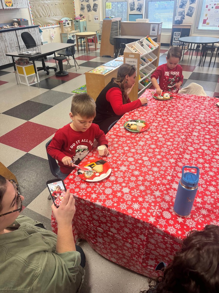 Preschoolers decorating cookies with adult