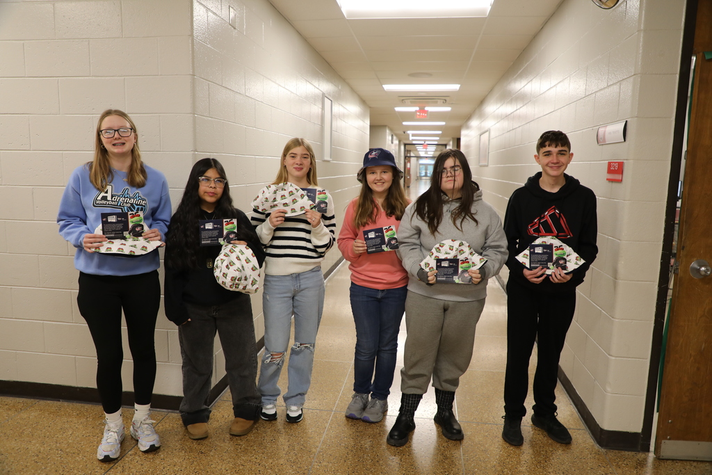 Students posing with tickets and hats