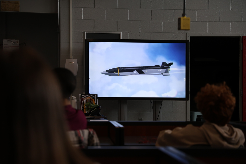 Students watching Anduril video on large TV screen
