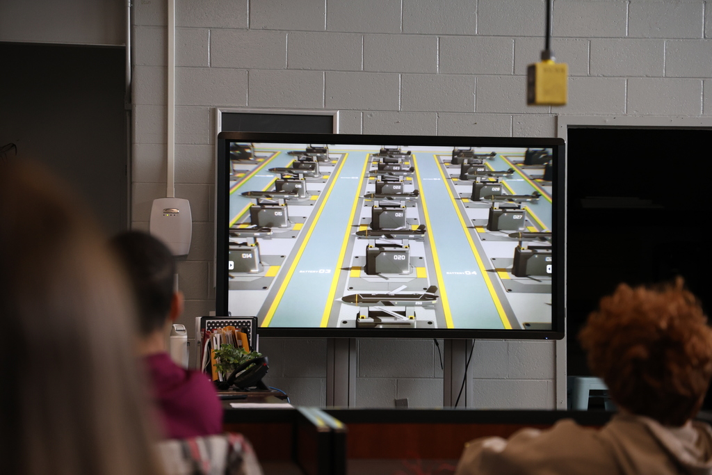 Students watching Anduril video on large TV screen