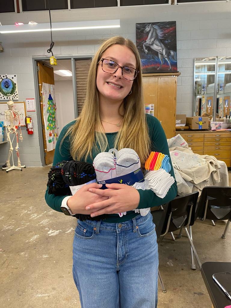 Student holding several pairs of socks