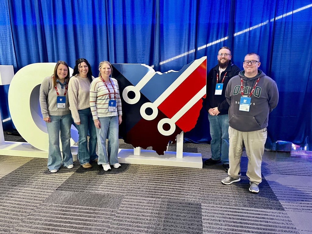 Staff with the OETC letter sign