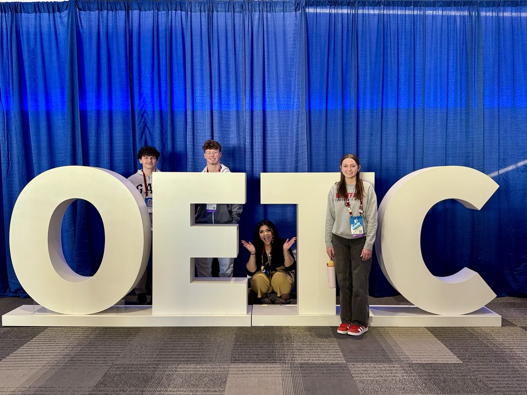 Students with the OETC letter sign