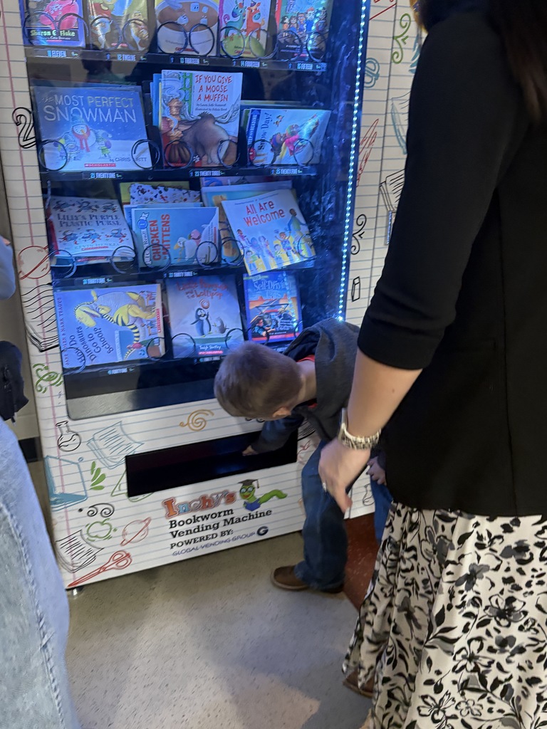 Student getting book from book vending machine