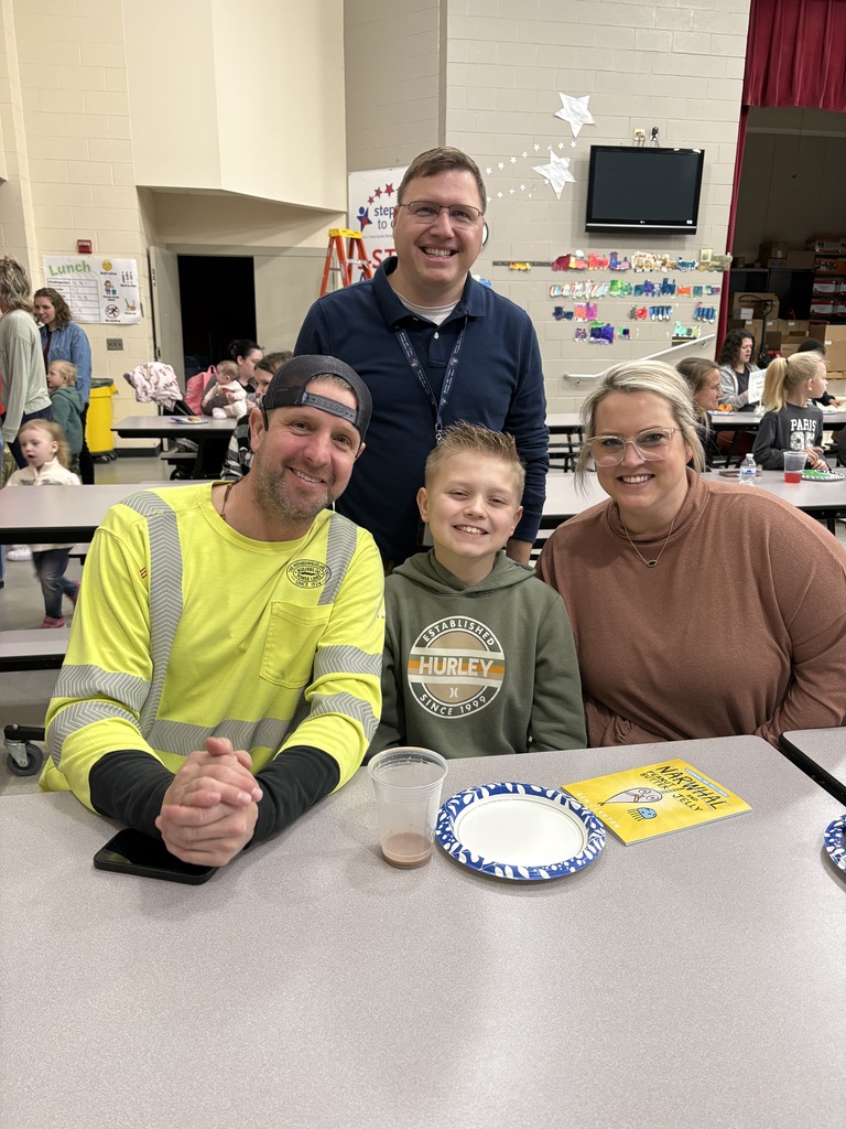Students of the Month smiling with their parents and teacher