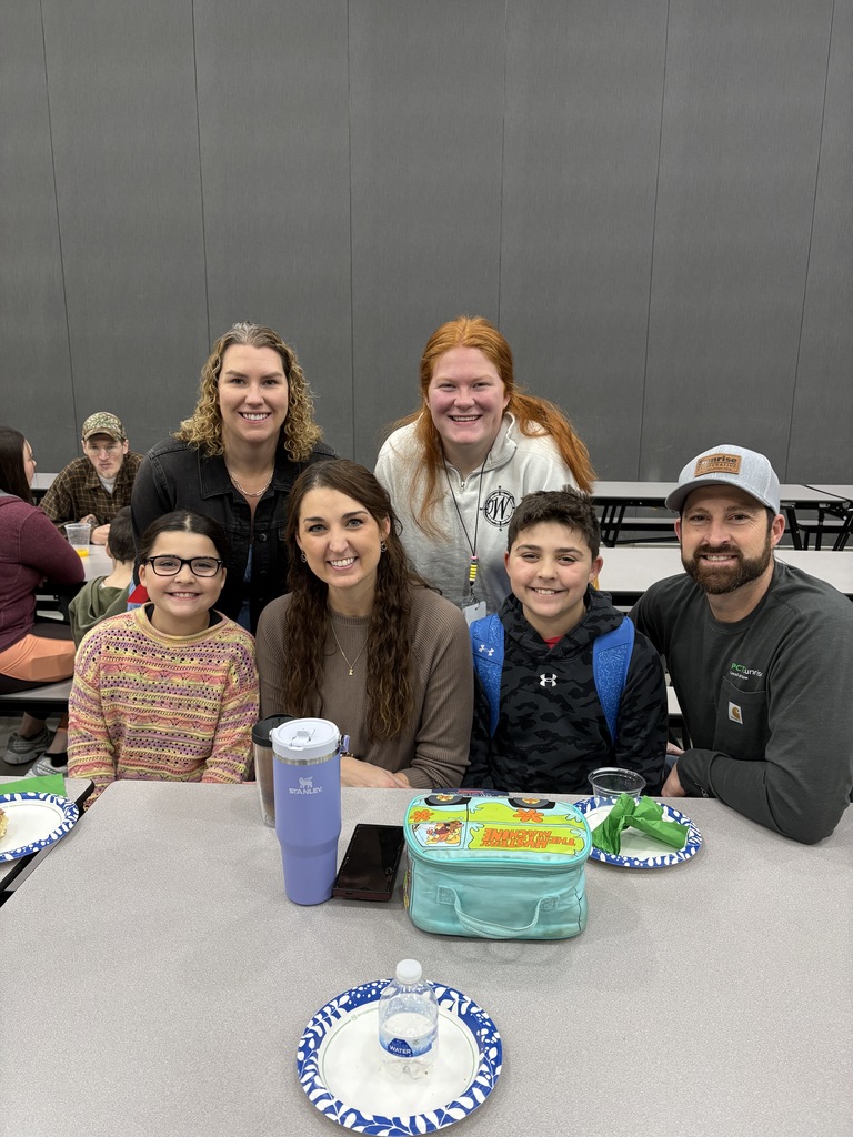Students of the Month smiling with their parents and teacher