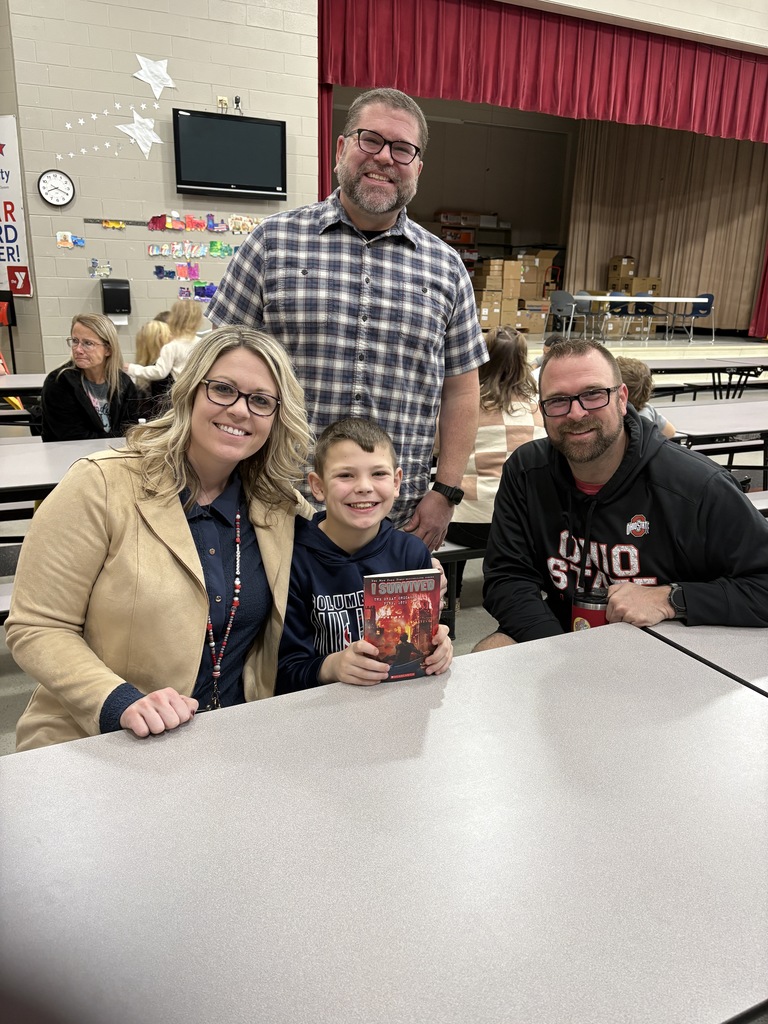 Students of the Month smiling with their parents and teacher