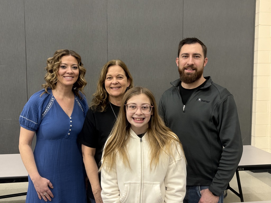 Students of the Month smiling with their parents and teacher