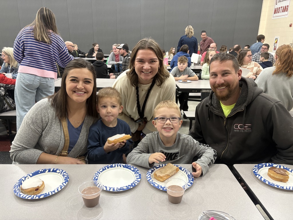 Students of the Month smiling with their parents and teacher
