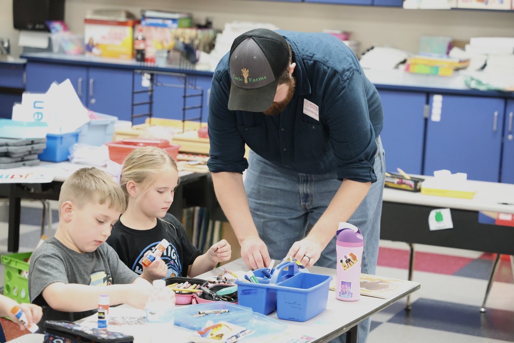 Man in hat helping female student