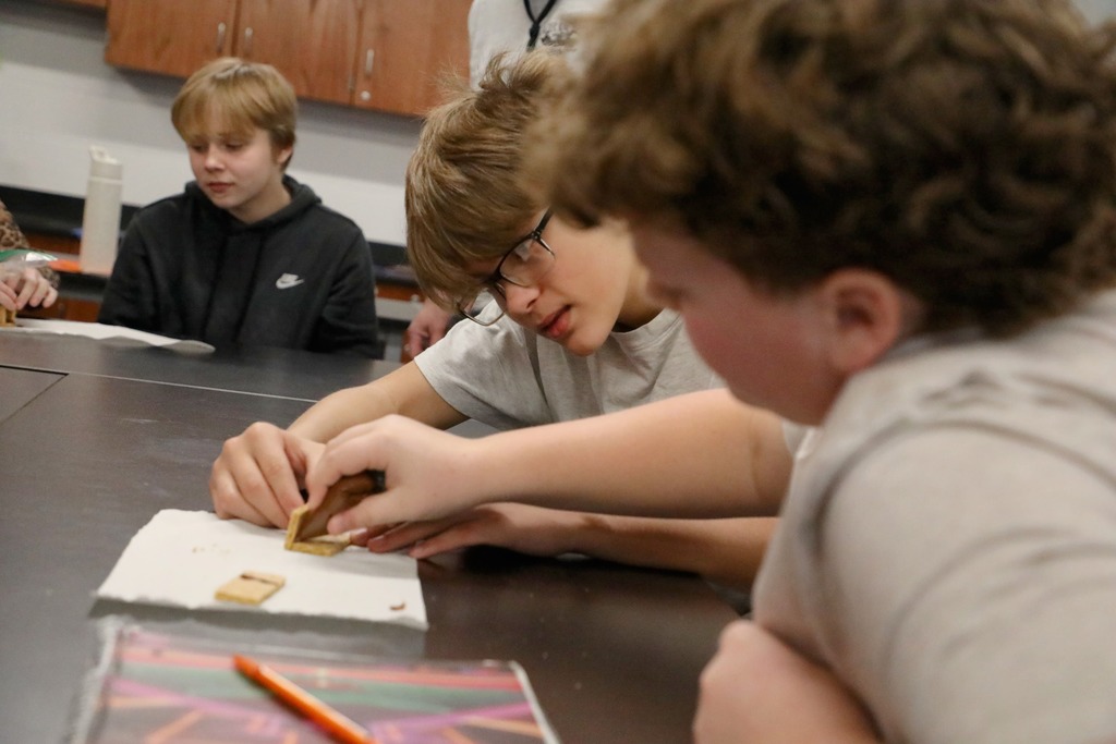 Students "welding" graham crackers held together with chocolate frosting
