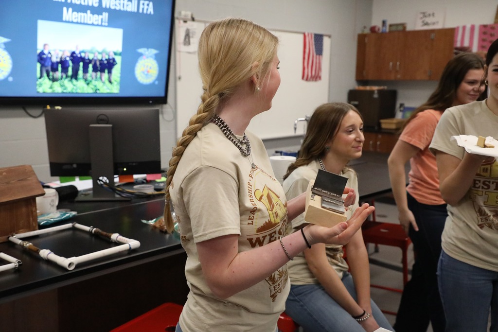 Student holding board with welded pieces attached