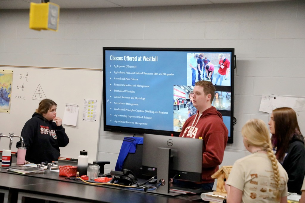 Student presenting in front of TV screen