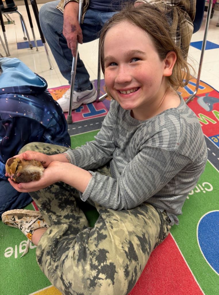 Student holding baby chick