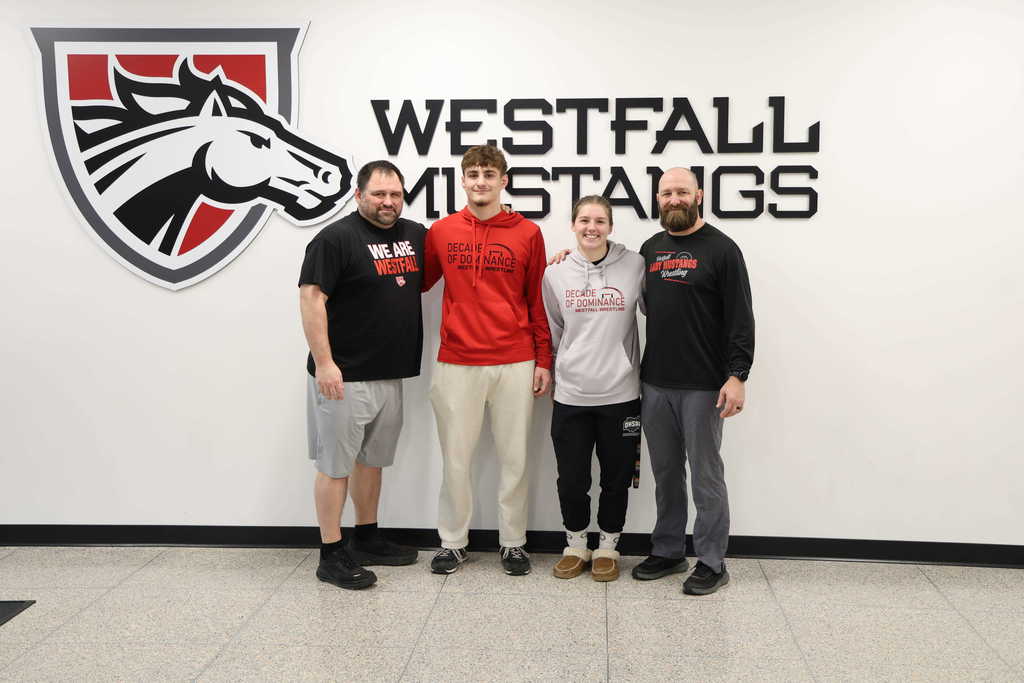 Coaches and wrestlers posing and smiling