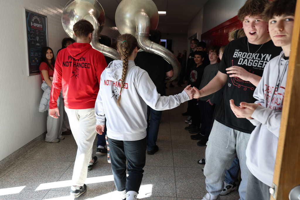 wrestlers shaking hands with fellow students in hallway
