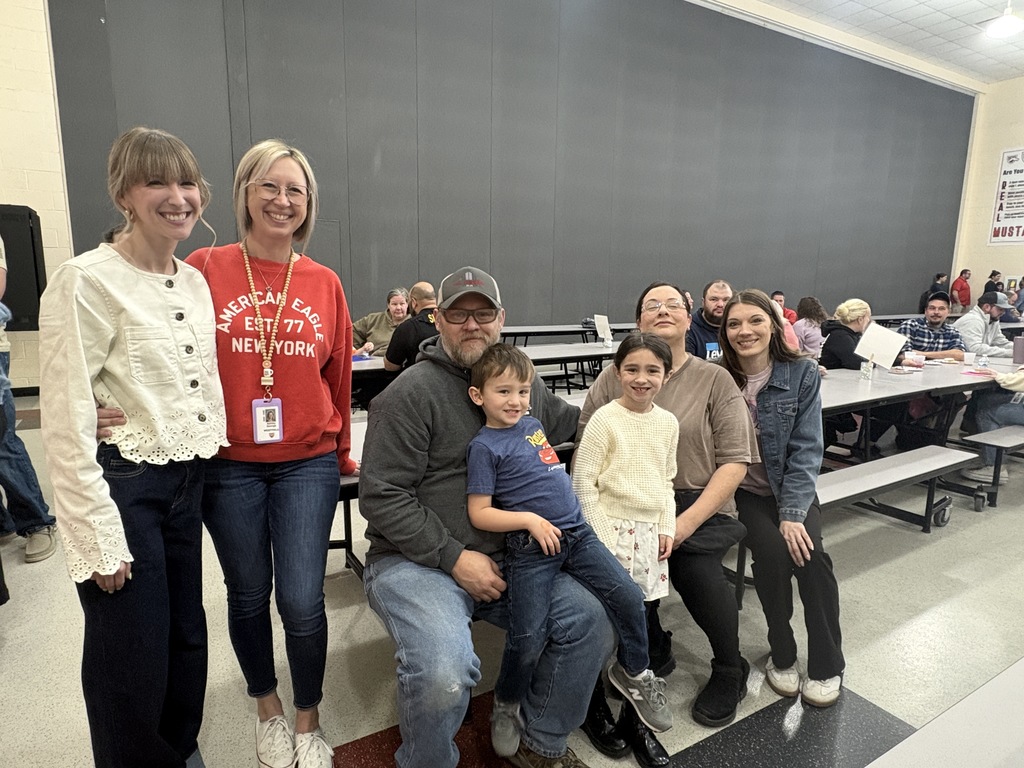 Students of the Month smiling with their parents and teacher