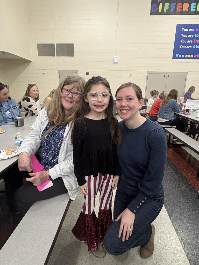 Students of the Month smiling with their parents and teacher