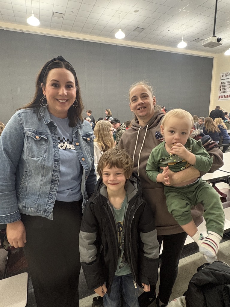Students of the Month smiling with their parents and teacher