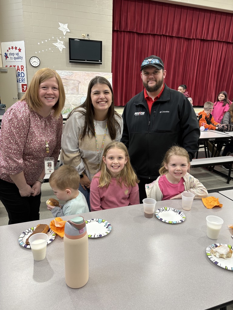 Students of the Month smiling with their parents and teacher