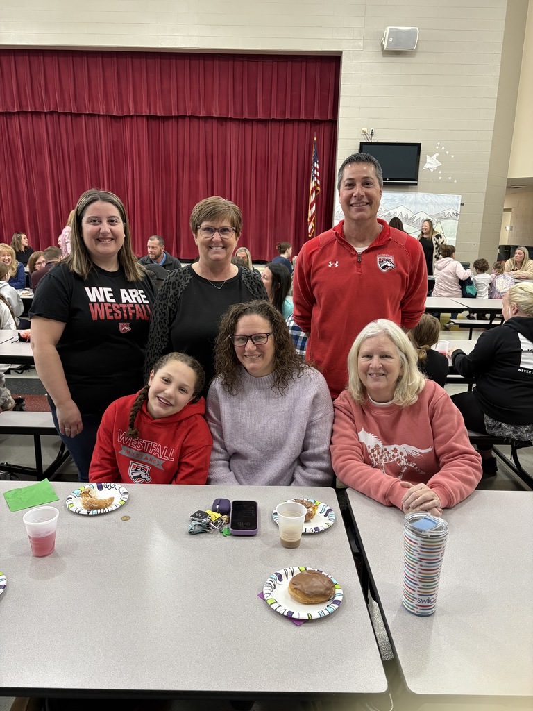 Students of the Month smiling with their parents and teacher