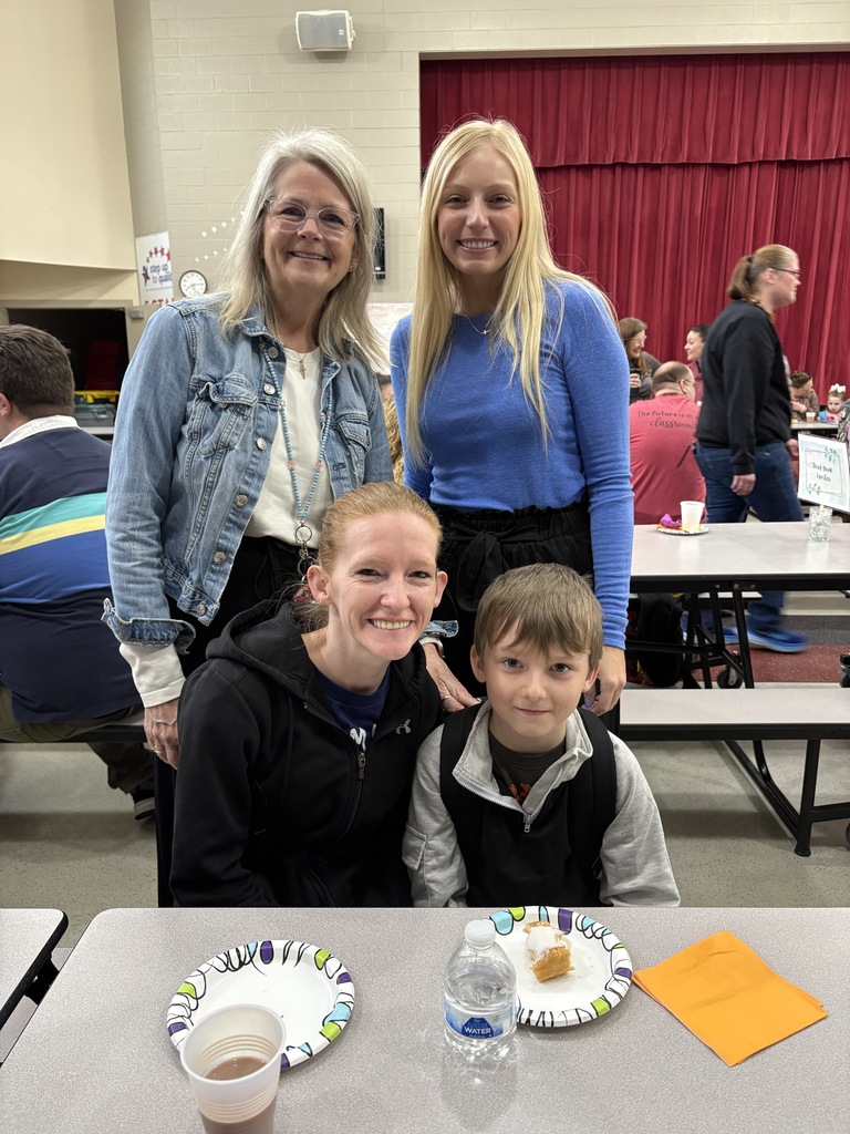 Students of the Month smiling with their parents and teacher