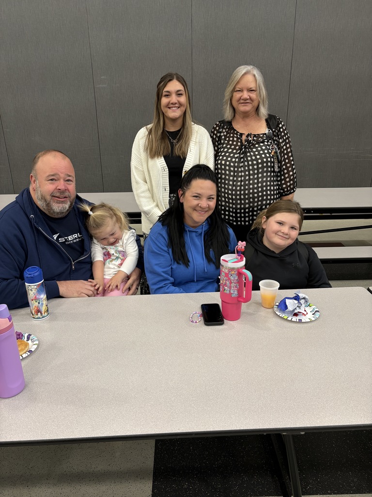 Students of the Month smiling with their parents and teacher
