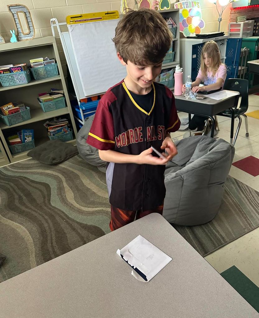 Ian looking at a baseball card and smiling