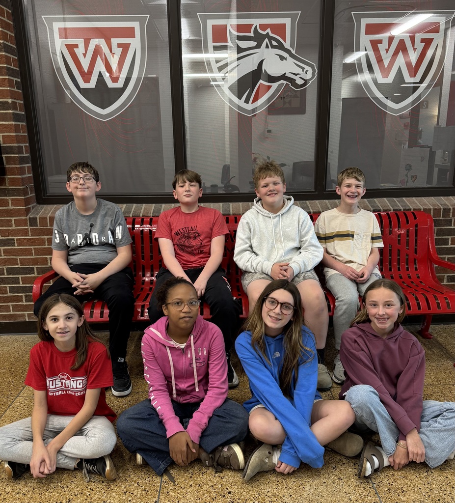 Groups of coed students sitting in front of Westfall Local School District logos