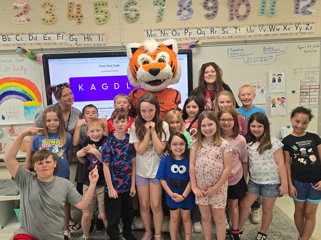 Cincinnati Bengals mascot posing with a class of male and female students with a teacher standing in the back