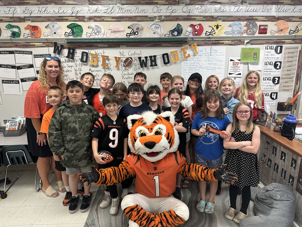 Cincinnati Bengals mascot posing with a class of male and female students with a teacher standing in the back