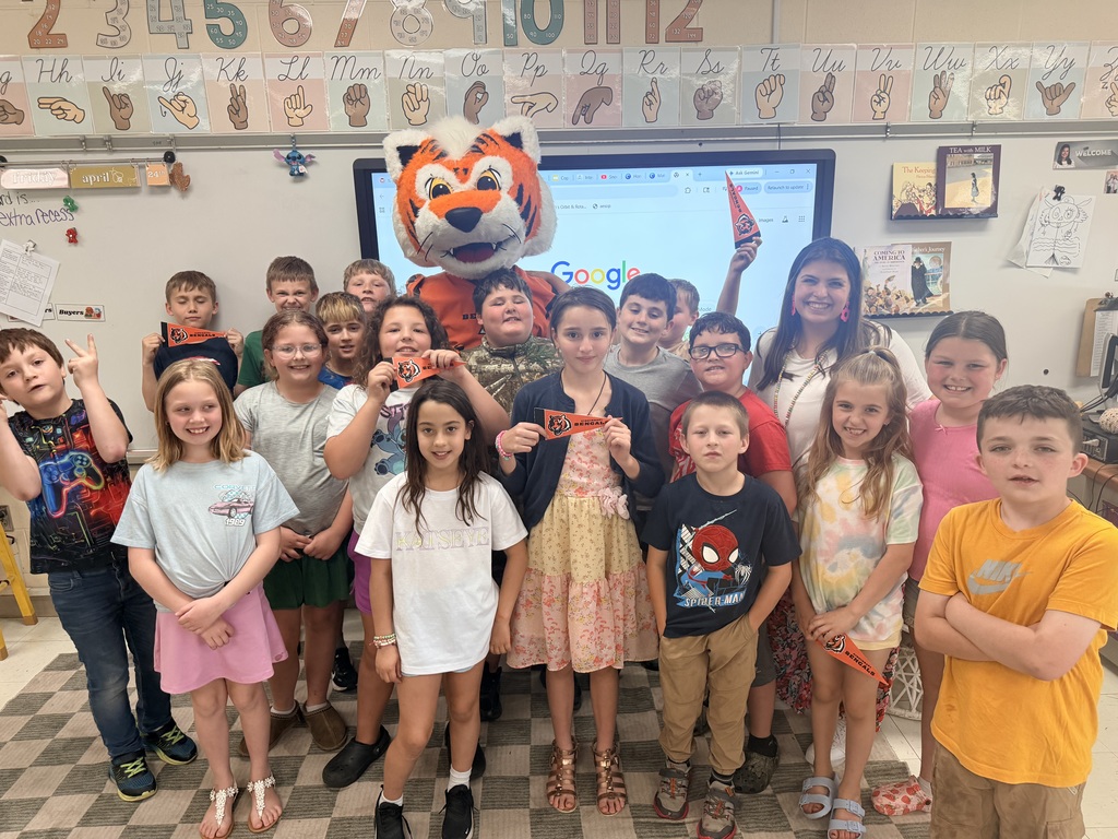 Cincinnati Bengals mascot posing with a class of male and female students with a teacher standing in the back
