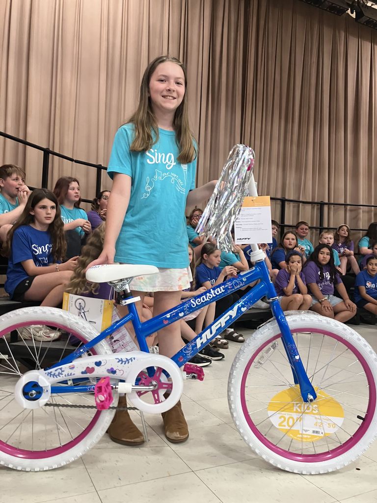 A student posing with a bicycle