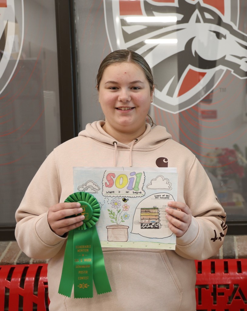 Picture of Addison Baltzer smiling and holding poster and ribbon