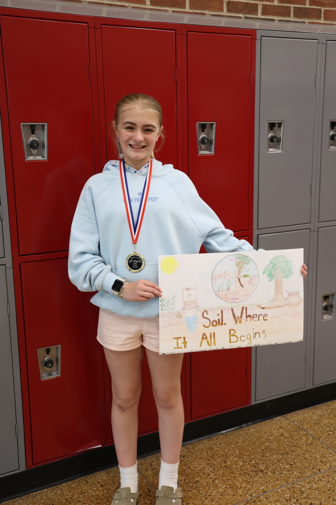 Brooklyn Steward smiling and holding her winning poster and wearing her medal