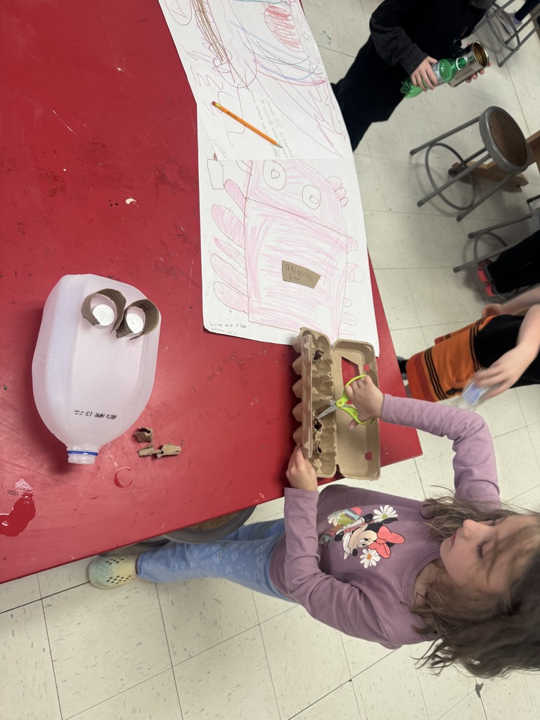 Student posing with environmental art piece