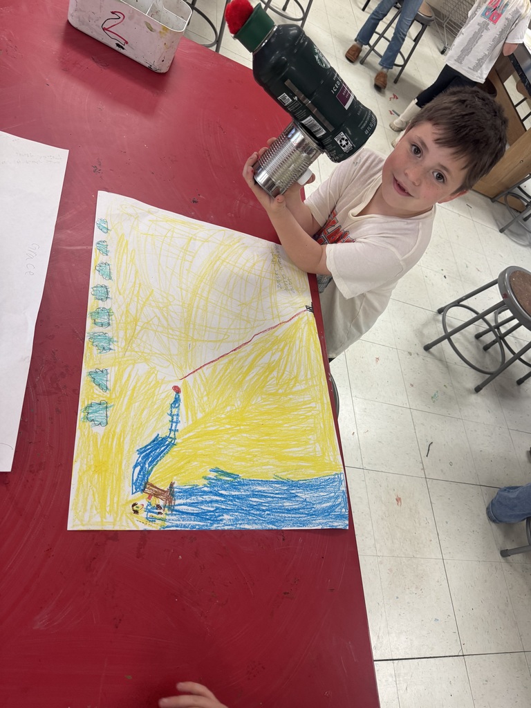 Student posing with environmental art piece