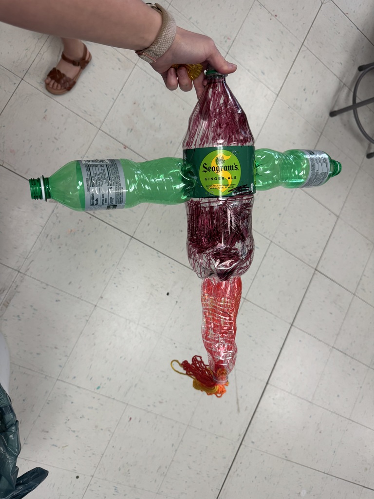 Student posing with environmental art piece