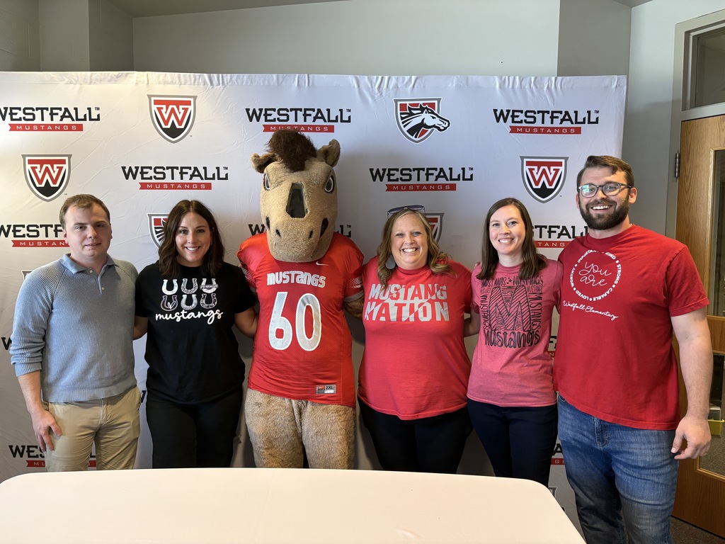 Group of teachers posing with Mustang mascot with the Westfall backdrop in the background